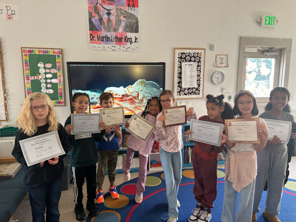 Third grade Mandarin Chinese students from The Children’s School smile and hold their certificates after being recognized in the Georgia Chinese Language Educators Hard Pen Calligraphy Competition.
